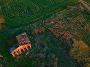 Home in a field with damage requiring the help of a public adjuster for a roof claim.